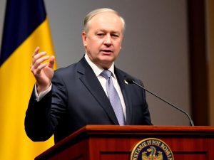 Președintele român gesticulând la pupitrul de vorbitori.